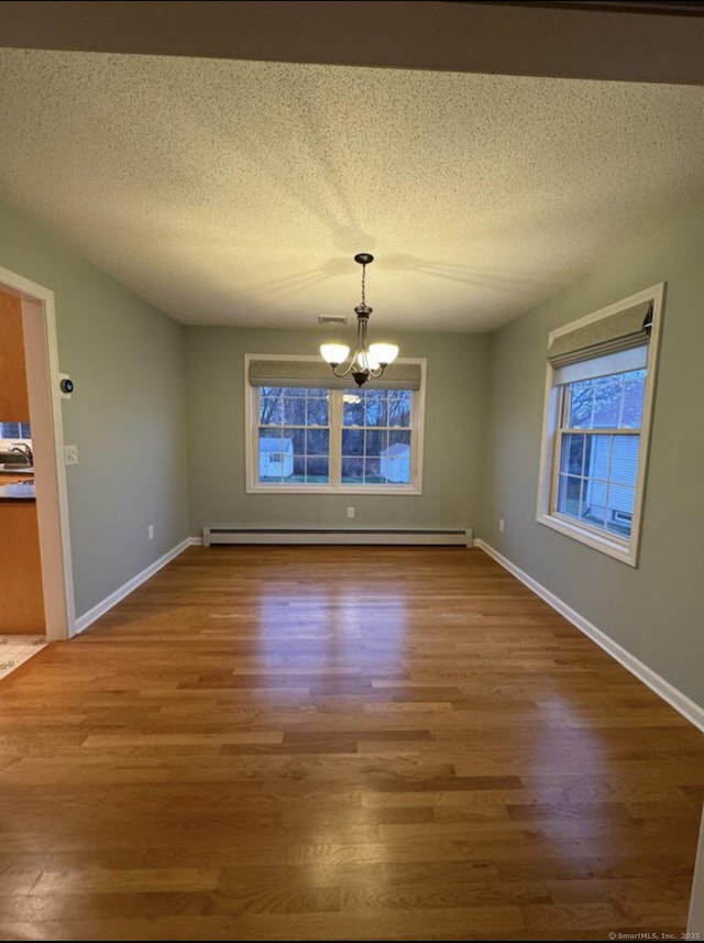 126 Sunnydale Ave, Bristol, CT 06010 - unfurnished dining area featuring a chandelier, a baseboard heating unit, wood finished floors, and a textured ceiling