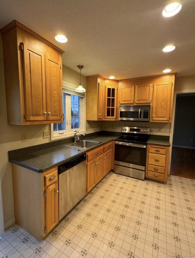 126 Sunnydale Ave, Bristol, CT 06010 - kitchen featuring appliances with stainless steel finishes, dark countertops, recessed lighting, pendant lighting, and glass insert cabinets