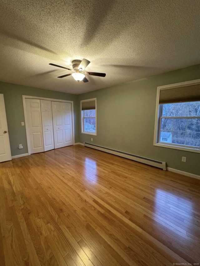 126 Sunnydale Ave, Bristol, CT 06010 - unfurnished bedroom featuring a baseboard radiator, wood finished floors, a textured ceiling, a closet, and a ceiling fan