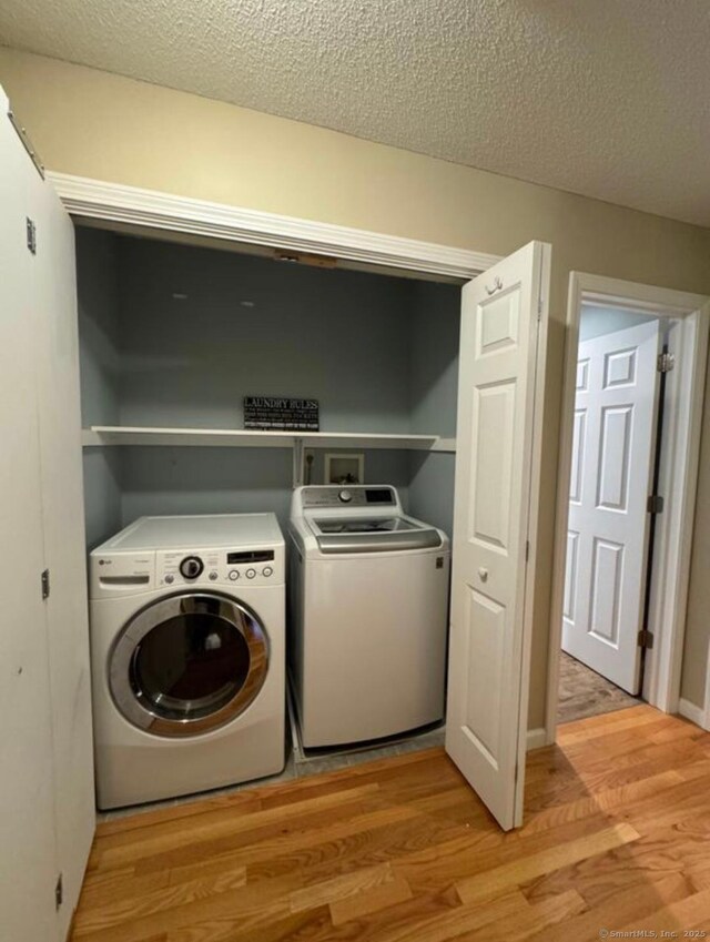126 Sunnydale Ave, Bristol, CT 06010 - laundry area with independent washer and dryer, light wood-style floors, and a textured ceiling