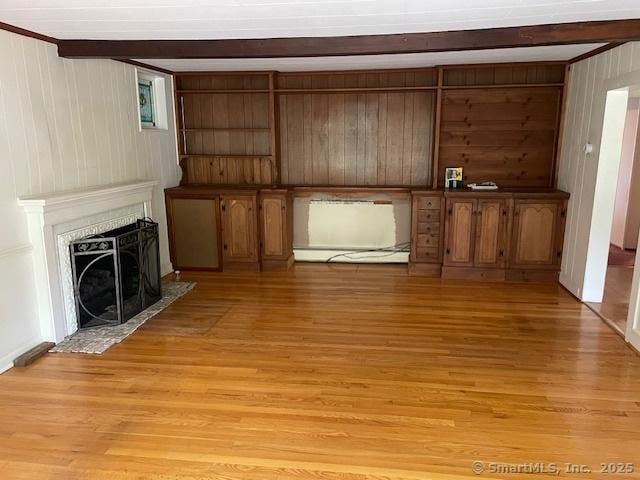 574 Cutlers Farm Rd, Monroe, CT 06468 - unfurnished living room with light wood-type flooring, beam ceiling, wood walls, and a fireplace