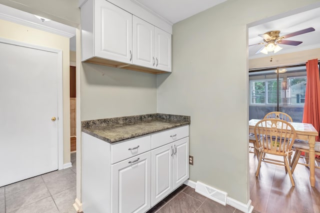 233 Derby Ave Unit 103, Derby, CT 06418 - kitchen featuring dark countertops, ceiling fan, white cabinetry, ornamental molding, and light tile patterned floors