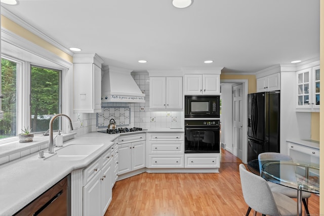 1981 Asylum Ave, West Hartford, CT 06117 - kitchen featuring black appliances, premium range hood, white cabinets, crown molding, and light countertops