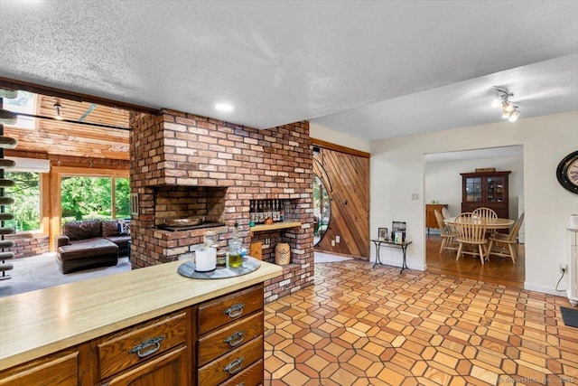57 Notch Hill Rd, North Branford, CT 06471 - kitchen featuring a textured ceiling, brown cabinetry, and open floor plan