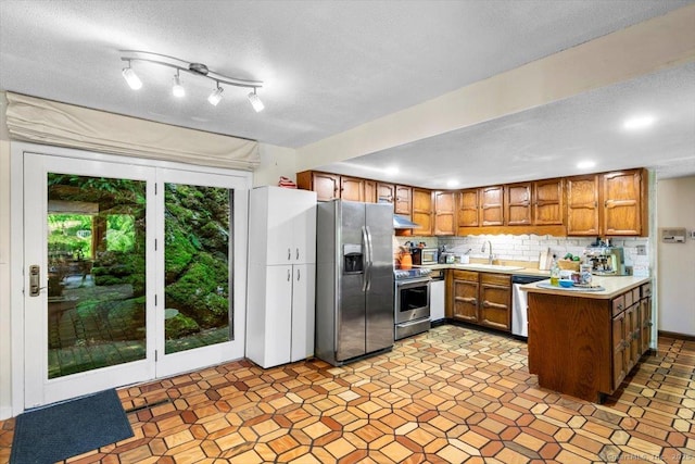 57 Notch Hill Rd, North Branford, CT 06471 - kitchen featuring appliances with stainless steel finishes, brown cabinets, light countertops, a peninsula, and decorative backsplash