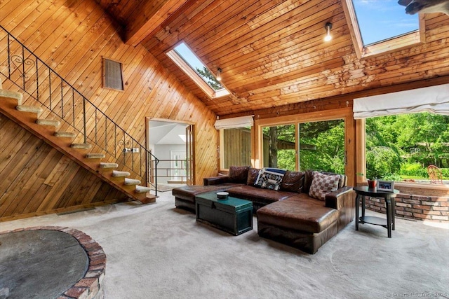 57 Notch Hill Rd, North Branford, CT 06471 - carpeted living area with high vaulted ceiling, wood walls, a skylight, a wooden ceiling with exposed beams, and stairs