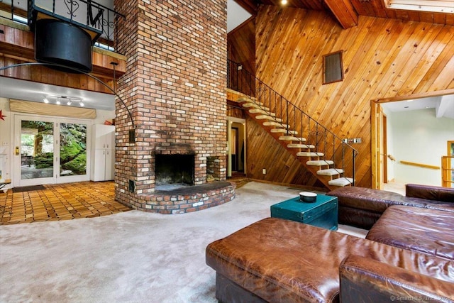 57 Notch Hill Rd, North Branford, CT 06471 - carpeted living room featuring a towering ceiling, stairs, wooden walls, a fireplace, and beamed ceiling