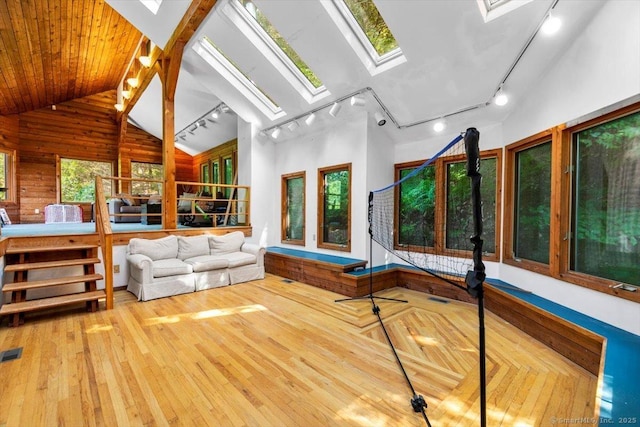 57 Notch Hill Rd, North Branford, CT 06471 - living room with rail lighting, a skylight, hardwood / wood-style flooring, wood walls, and vaulted ceiling