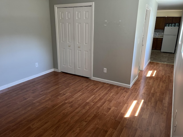 137 Judd Sq Unit 137, Wallingford, CT 06492 - unfurnished bedroom with freestanding refrigerator, dark wood-type flooring, and a closet