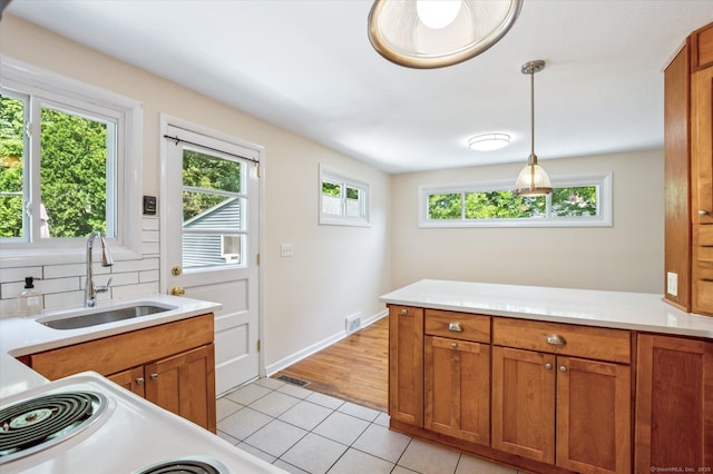 10 John Smith Dr, West Hartford, CT 06107 - kitchen featuring light tile patterned floors, brown cabinets, light countertops, and hanging light fixtures