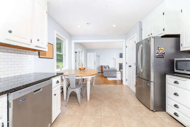 55 Charles Mary Dr, East Hampton, CT 06424 - kitchen featuring stainless steel appliances, tasteful backsplash, white cabinetry, dark stone countertops, and a fireplace