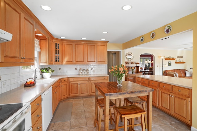 317 Victoria Lawn, Stratford, CT 06615 - kitchen featuring white dishwasher, arched walkways, light tile patterned floors, decorative backsplash, and recessed lighting