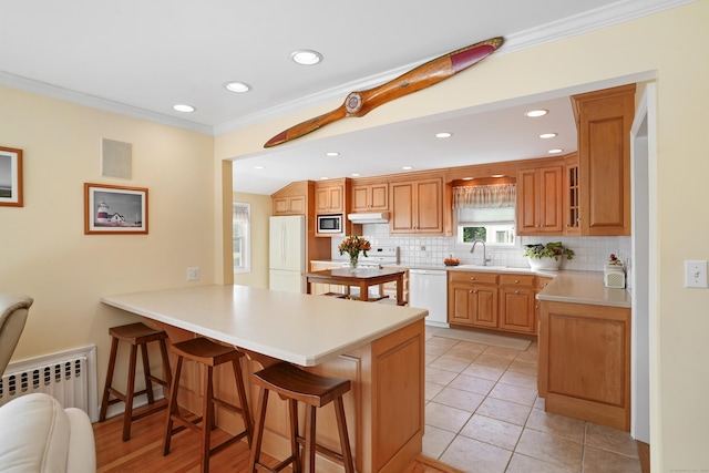 317 Victoria Lawn, Stratford, CT 06615 - kitchen with white appliances, a breakfast bar, a peninsula, under cabinet range hood, and tasteful backsplash