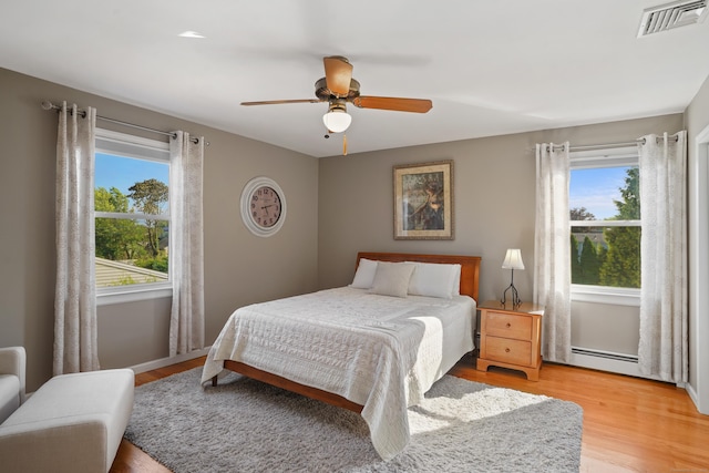317 Victoria Lawn, Stratford, CT 06615 - bedroom featuring a baseboard heating unit, light wood finished floors, and a ceiling fan