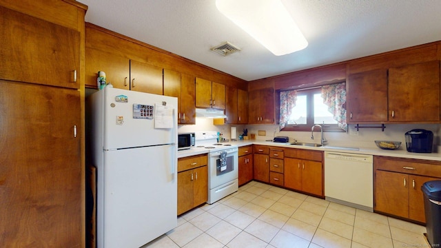 1102 Summer Hill Dr Unit 1102, South Windsor, CT 06074 - kitchen with white appliances, under cabinet range hood, light countertops, brown cabinetry, and light tile patterned flooring