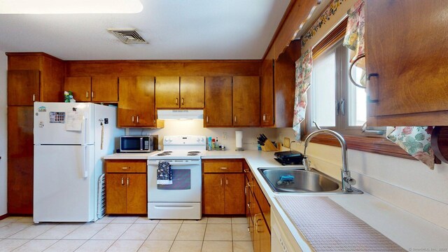 1102 Summer Hill Dr Unit 1102, South Windsor, CT 06074 - kitchen featuring white appliances, under cabinet range hood, brown cabinets, light countertops, and light tile patterned floors