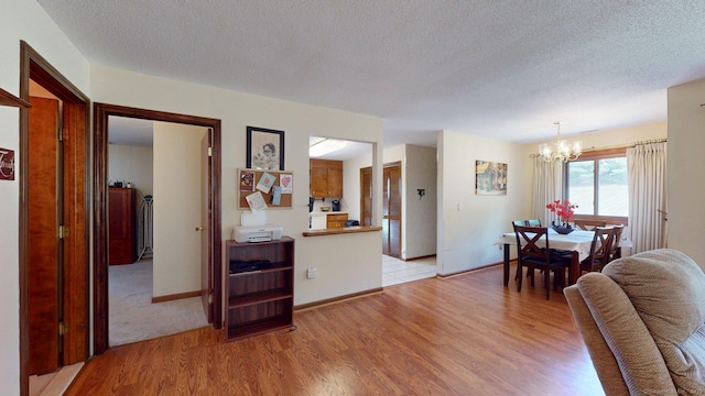 1102 Summer Hill Dr Unit 1102, South Windsor, CT 06074 - living room featuring a chandelier, light wood-type flooring, and a textured ceiling