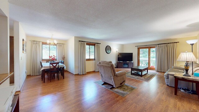 1102 Summer Hill Dr Unit 1102, South Windsor, CT 06074 - living area featuring a chandelier, wood finished floors, and a textured ceiling