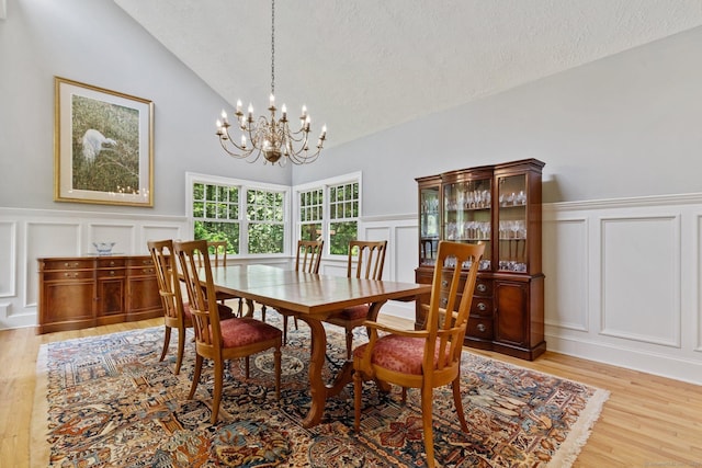 91 Fox Run Rd, New Canaan, CT 06840 - dining space featuring a decorative wall, a chandelier, light wood-style flooring, wainscoting, and a textured ceiling