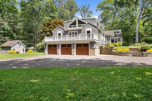 91 Fox Run Rd, New Canaan, CT 06840 - shingle-style home featuring stone siding, a front yard, asphalt driveway, a garage, and an outdoor structure