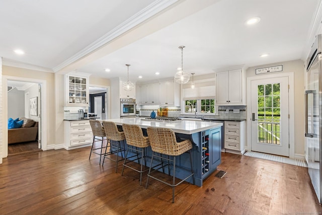 601 Old Stamford Rd, New Canaan, CT 06840 - kitchen featuring white cabinets, a breakfast bar, backsplash, dark wood-type flooring, and crown molding