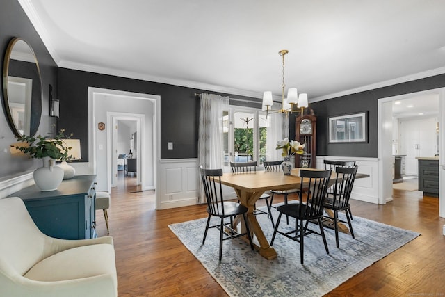 601 Old Stamford Rd, New Canaan, CT 06840 - dining space with a chandelier, wood finished floors, ornamental molding, a decorative wall, and wainscoting