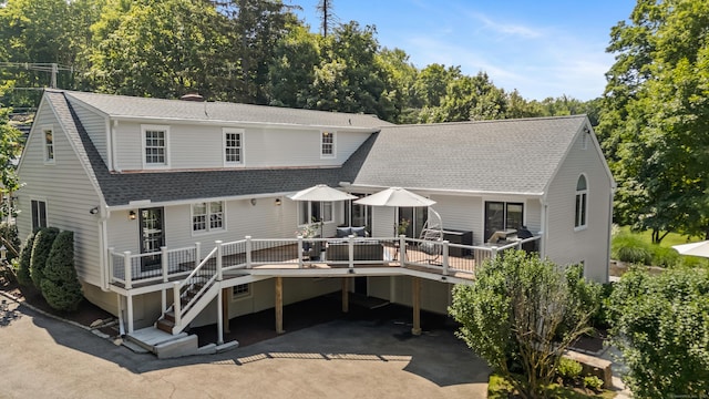 601 Old Stamford Rd, New Canaan, CT 06840 - rear view of property with roof with shingles, a wooden deck, view of scattered trees, and driveway