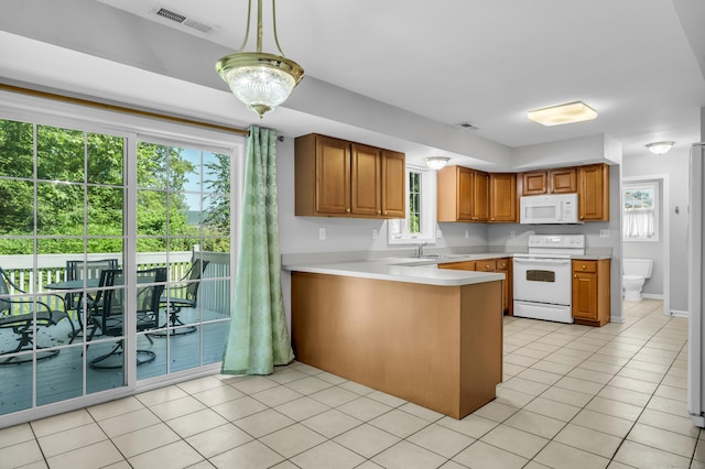 46 Pleasant Ave, Berlin, CT 06037 - kitchen featuring white appliances, a peninsula, light countertops, brown cabinetry, and light tile patterned floors