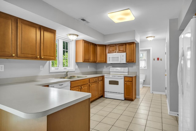 46 Pleasant Ave, Berlin, CT 06037 - kitchen with white appliances, light countertops, light tile patterned floors, a peninsula, and brown cabinetry