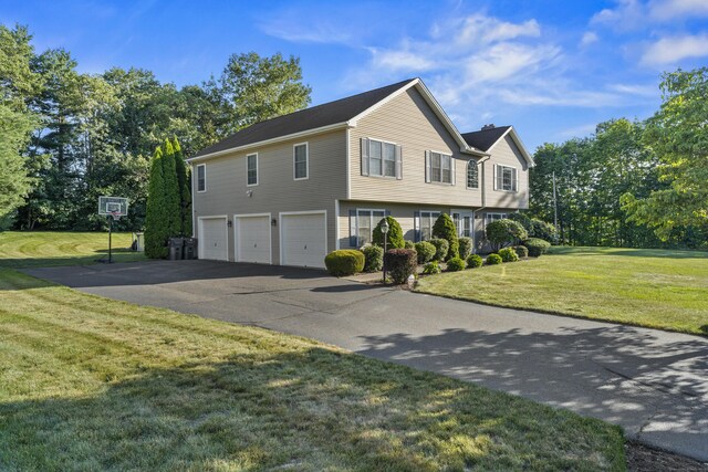 8 Barbara Ln, Southington, CT 06479 - view of front of home with a garage, asphalt driveway, a front lawn, and view of wooded area
