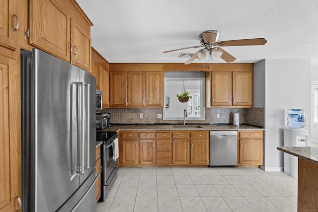 8 Barbara Ln, Southington, CT 06479 - kitchen featuring appliances with stainless steel finishes, brown cabinetry, and tasteful backsplash