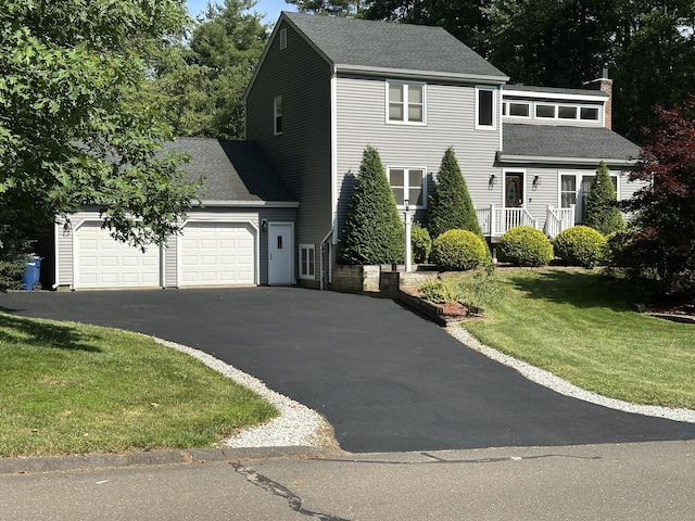 2 Evergreen Dr, Granby, CT 06035 - view of front of house with asphalt driveway, a chimney, a garage, a front lawn, and a shingled roof