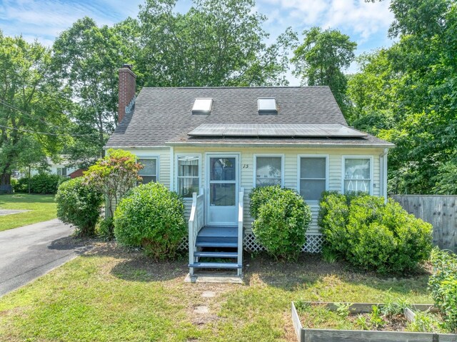 15 Hawks Nest Rd, Old Lyme, CT 06371 - view of front of house featuring solar panels, a garden, a chimney, and a shingled roof
