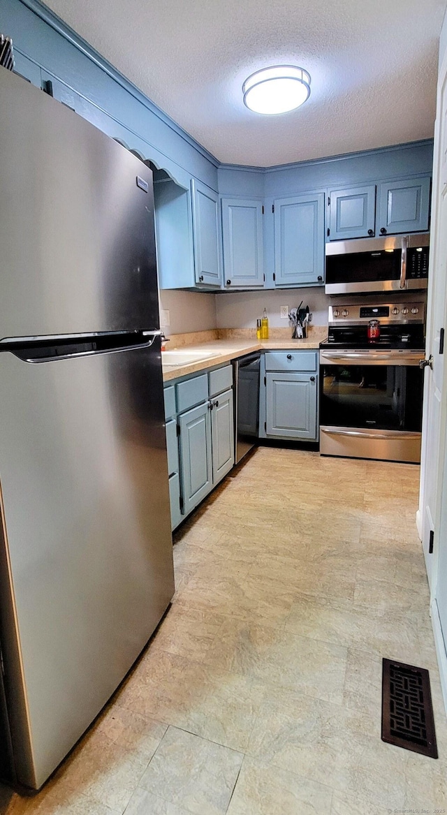 145 Brighton Cir, Windsor, CT 06095 - kitchen with appliances with stainless steel finishes, light countertops, and a textured ceiling