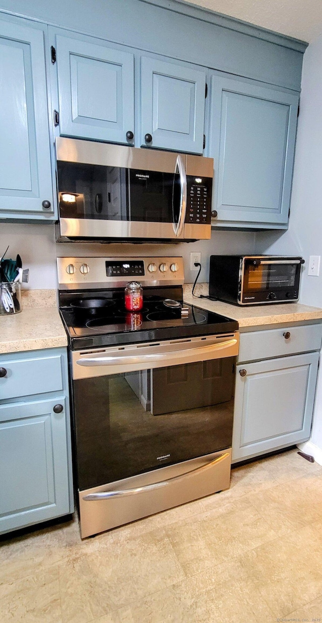 145 Brighton Cir, Windsor, CT 06095 - kitchen with stainless steel appliances, light countertops, and blue cabinetry