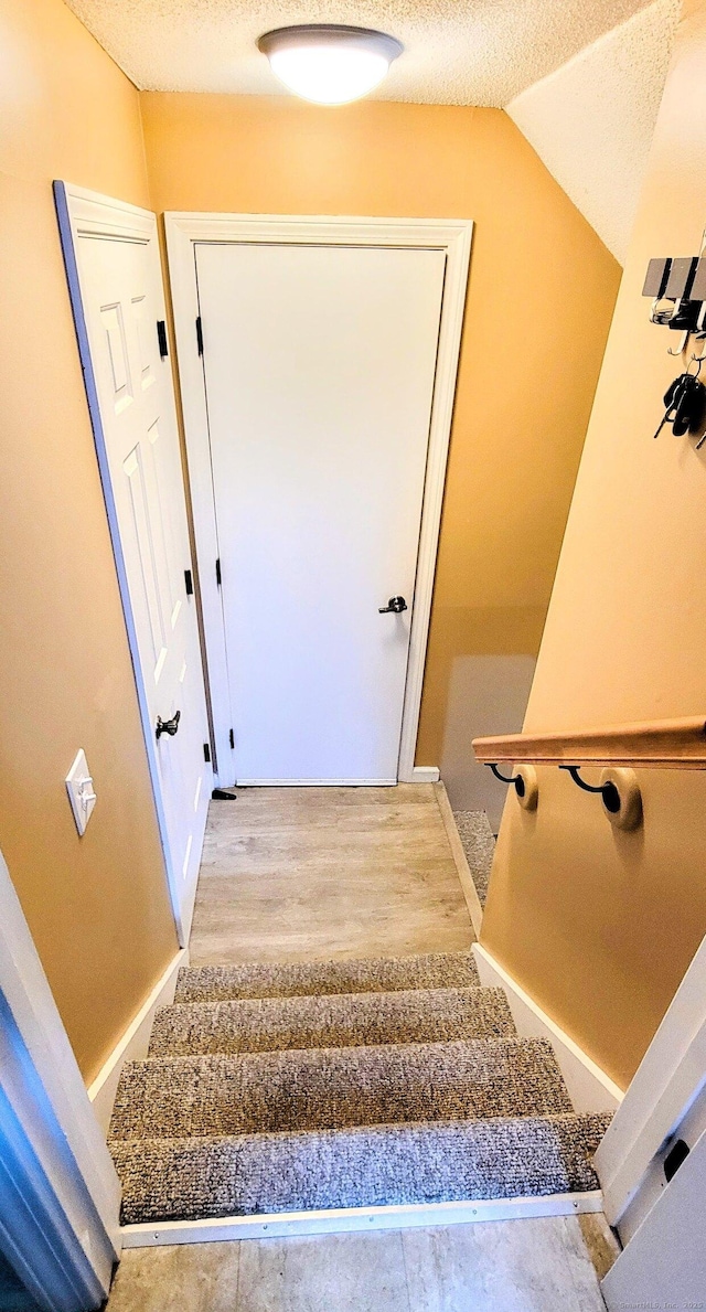 145 Brighton Cir, Windsor, CT 06095 - stairway featuring wood finished floors, a textured ceiling, and vaulted ceiling