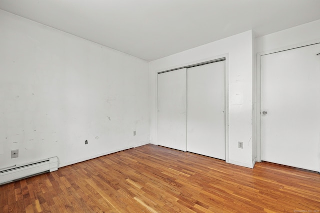 21 Gilbert Hill Rd, Norwalk, CT 06853 - unfurnished bedroom with a baseboard heating unit and light wood-style floors