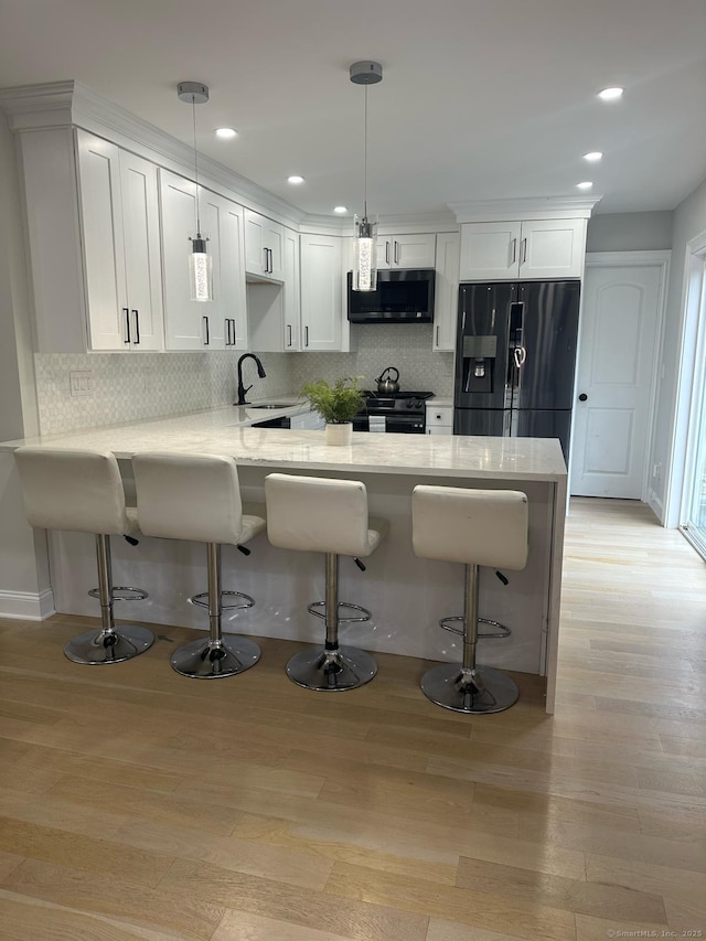 60 Carlson Ave, Bridgeport, CT 06606 - kitchen with black appliances, a peninsula, white cabinetry, tasteful backsplash, and recessed lighting
