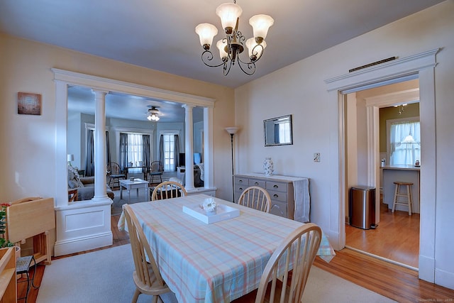 32 Columbus St, East Hartford, CT 06108 - dining space with decorative columns, light wood-style flooring, and a chandelier