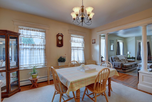 32 Columbus St, East Hartford, CT 06108 - dining space featuring ornate columns, wood finished floors, a chandelier, and a baseboard heating unit