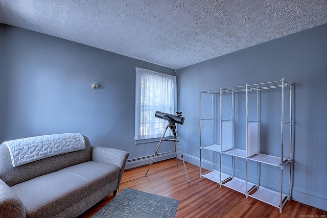 32 Columbus St, East Hartford, CT 06108 - sitting room featuring baseboard heating, wood finished floors, and a textured ceiling