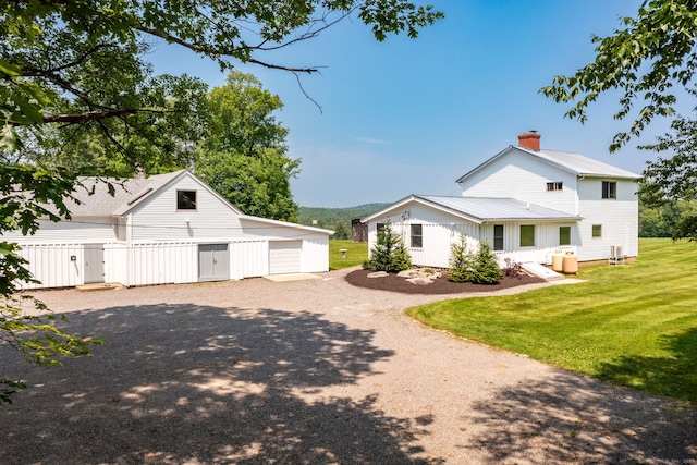 1669 Rte 169, Woodstock, CT 06281 - view of property exterior featuring a detached garage, a lawn, a chimney, an outbuilding, and gravel driveway