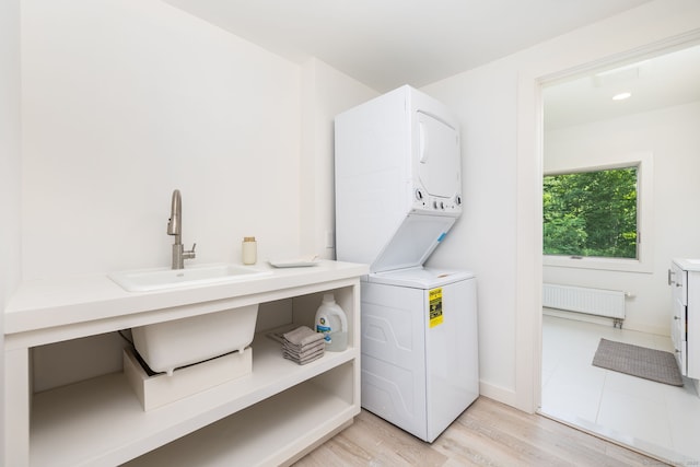 1669 Rte 169, Woodstock, CT 06281 - laundry room featuring stacked washing machine and dryer, radiator, and light wood-style floors