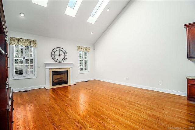 66 Watkins Dr Unit 66, Newtown, CT 06482 - unfurnished living room featuring a high end fireplace, a skylight, high vaulted ceiling, light wood finished floors, and recessed lighting