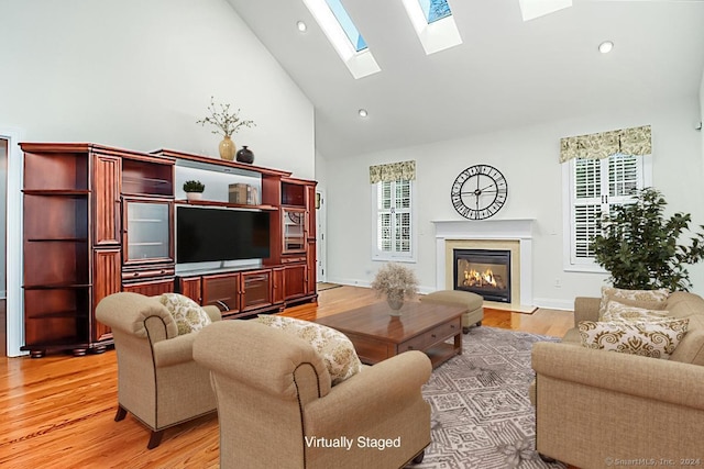 66 Watkins Dr Unit 66, Newtown, CT 06482 - living area with a fireplace with flush hearth, high vaulted ceiling, plenty of natural light, light wood-type flooring, and a skylight