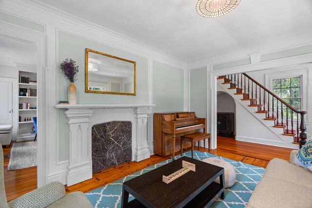 109 Boston Post Rd, Madison, CT 06443 - living area featuring ornamental molding, hardwood / wood-style flooring, stairs, a fireplace, and a decorative wall