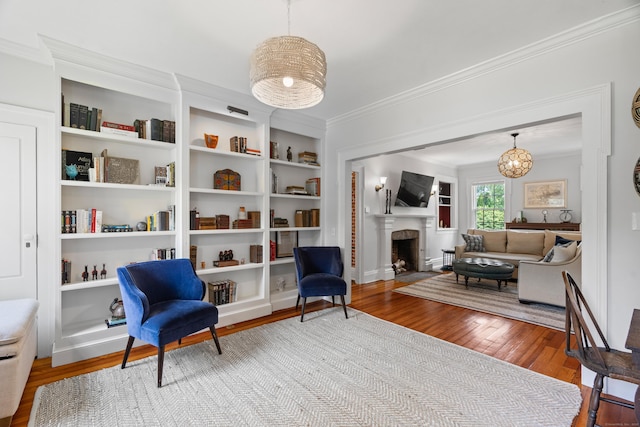 109 Boston Post Rd, Madison, CT 06443 - sitting room featuring wood finished floors, ornamental molding, a fireplace with flush hearth, built in features, and a chandelier