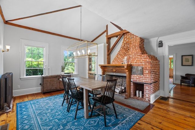 109 Boston Post Rd, Madison, CT 06443 - dining space featuring radiator heating unit, wood-type flooring, a chandelier, ornamental molding, and a brick fireplace
