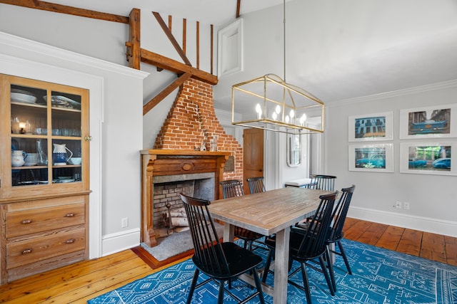 109 Boston Post Rd, Madison, CT 06443 - dining room featuring hardwood / wood-style floors, a chandelier, crown molding, and a brick fireplace