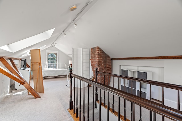109 Boston Post Rd, Madison, CT 06443 - hallway featuring vaulted ceiling, rail lighting, a skylight, light carpet, and an upstairs landing